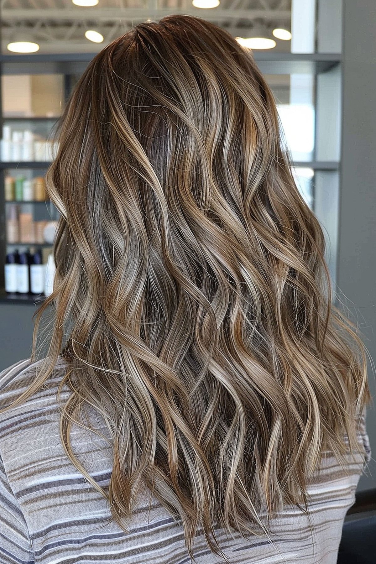 Long wavy warm brown hair with cool-toned highlights