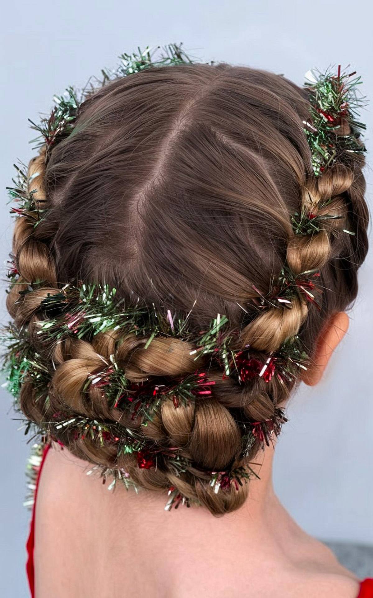 Braided crown with red and green tinsel weaved into the hair for a Christmas style