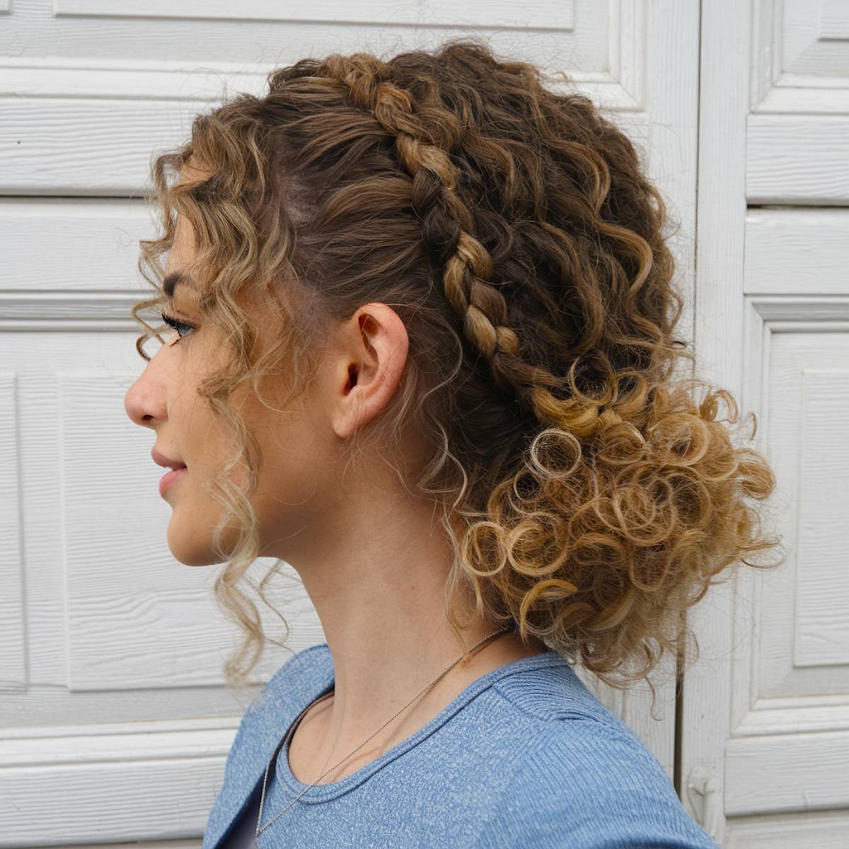 Curly hair bun featuring braided crown details for added texture and elegance