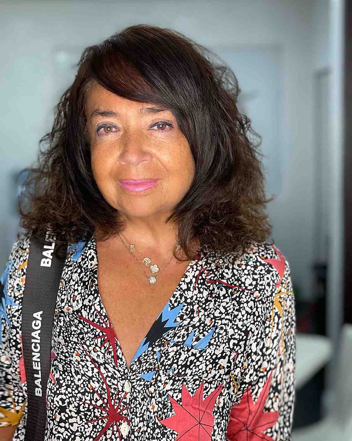 curly hair with side-swept bangs for women over 50