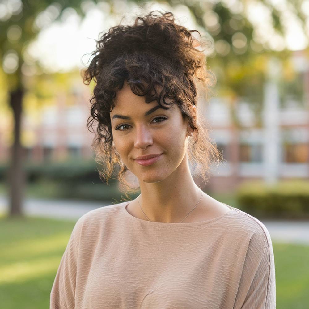 Curly high ponytail with loose face-framing tendrils and bangs, ideal for school or casual wear