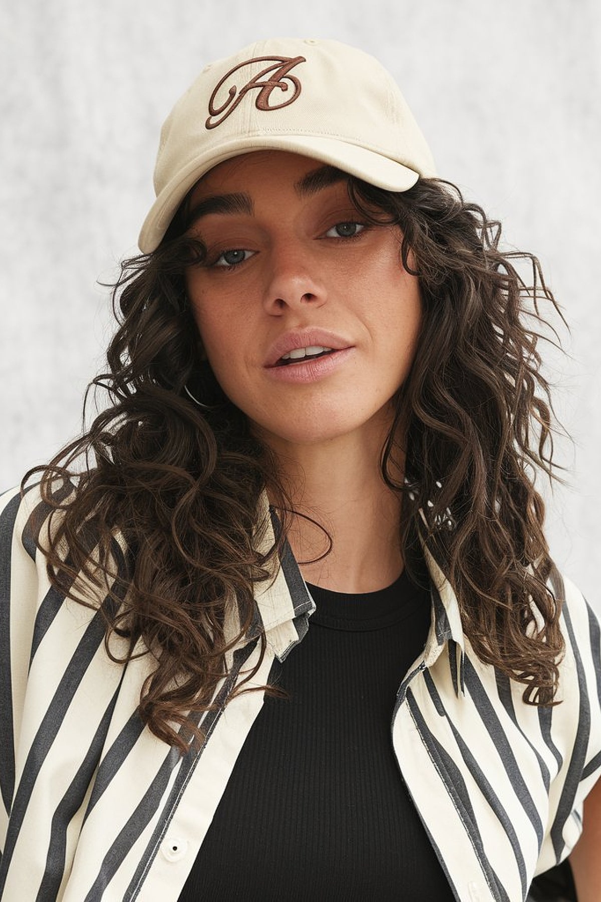 Sporty curly hair cap hairstyle with loose, defined curls