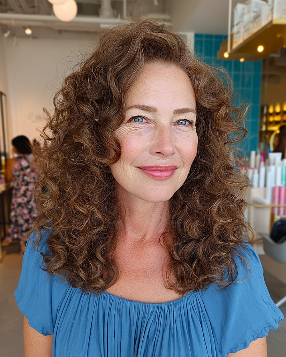 Medium curly hairstyle with lifted crown and soft volume for women over 50 with brown hair