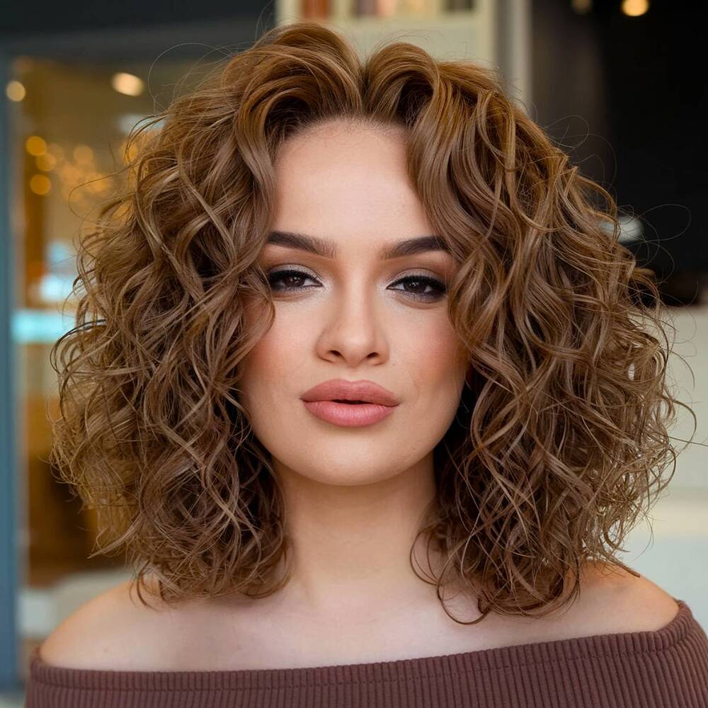 Shoulder-length curly haircut with natural volume and defined ringlets for a bouncy, full-bodied look