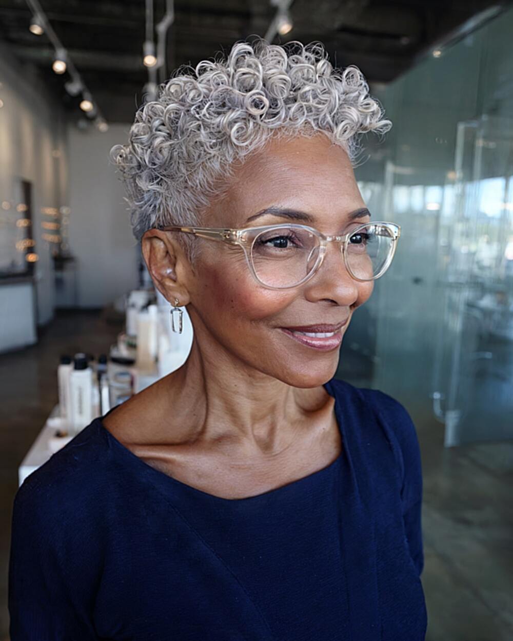 Tapered curly cut with defined coils for older women with short silver hair