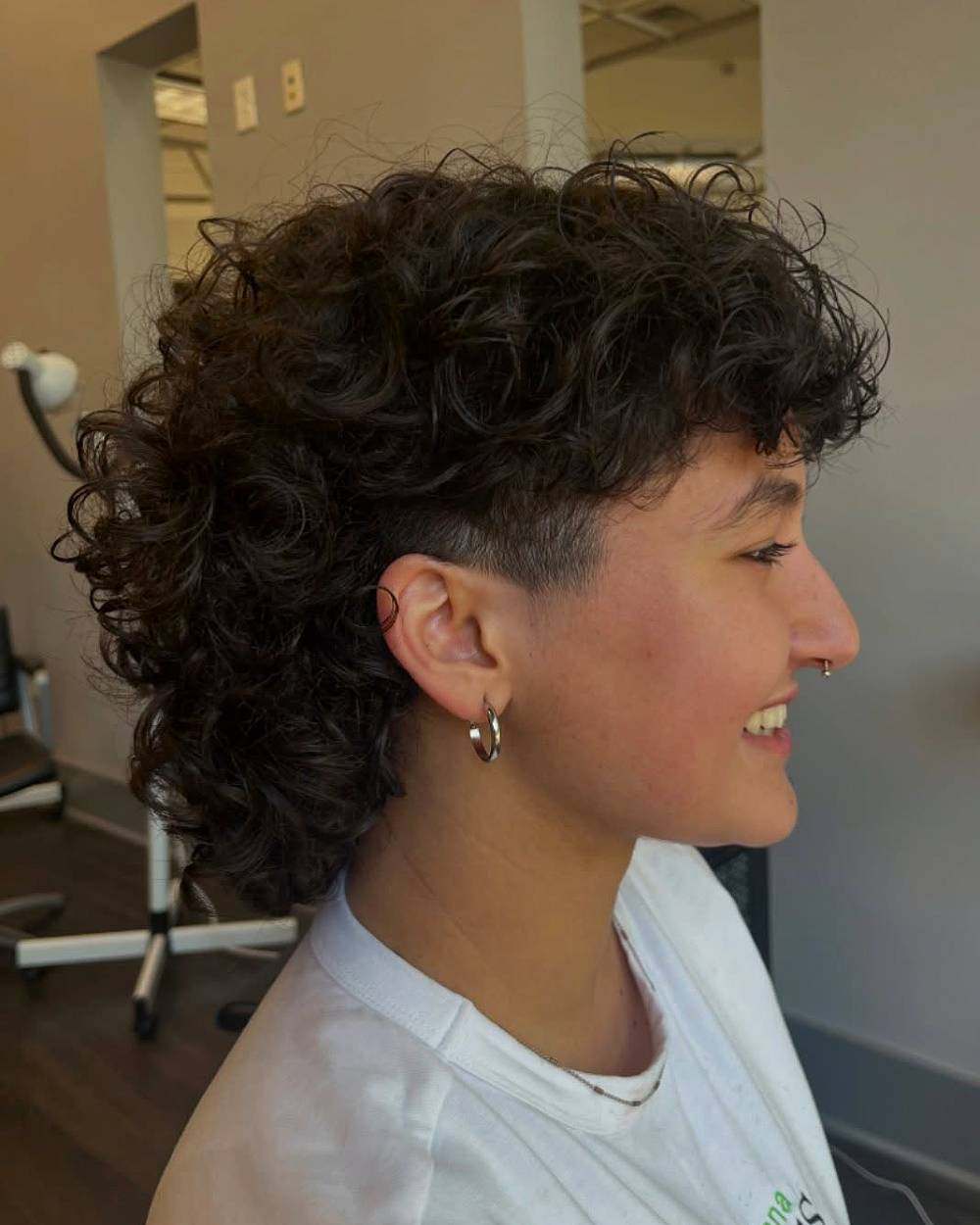 Curly tapered mullet with shaved sides, a bold modern mullet style for thick, textured hair