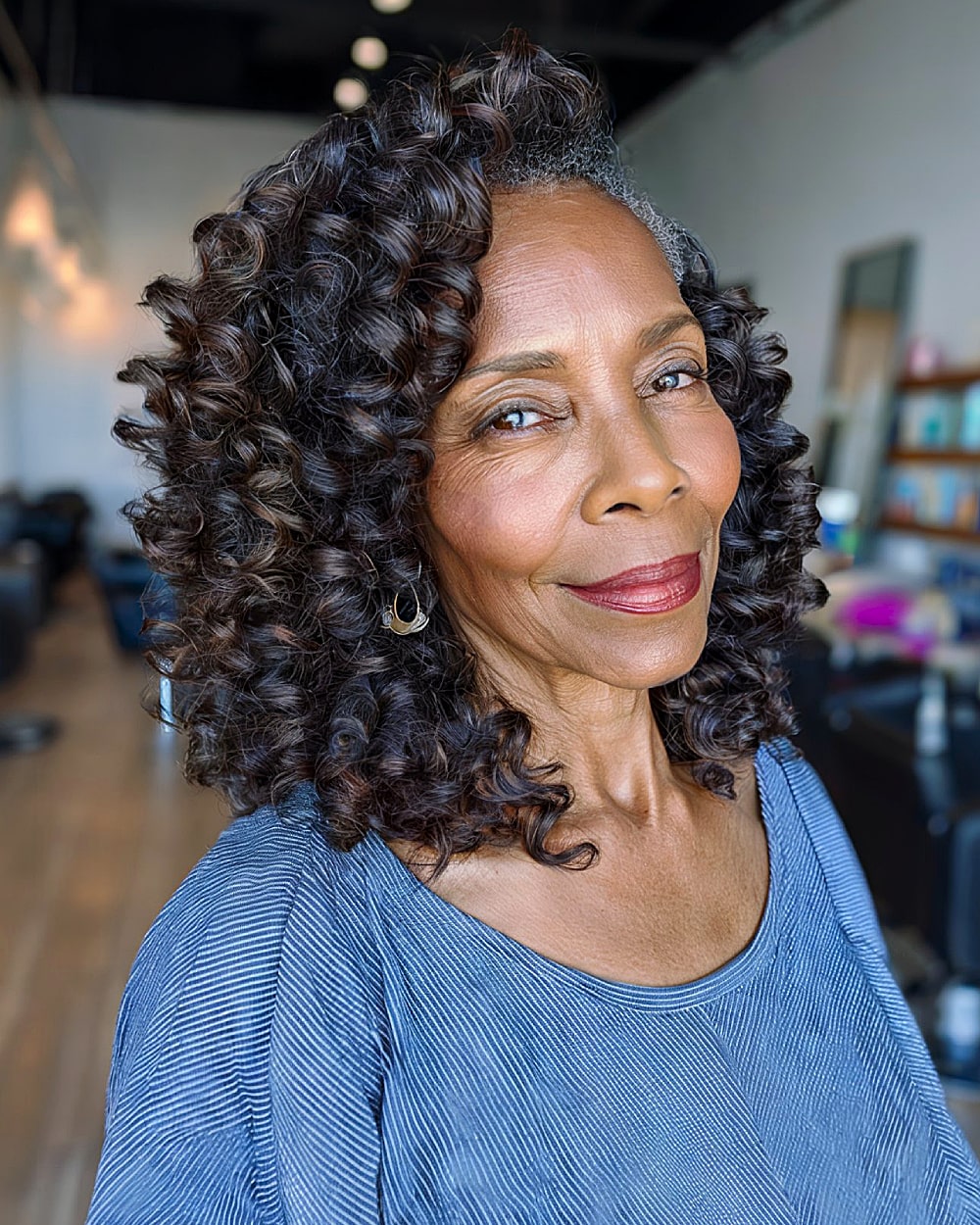 Defined voluminous ringlets with deep side part for older women with long coily hair