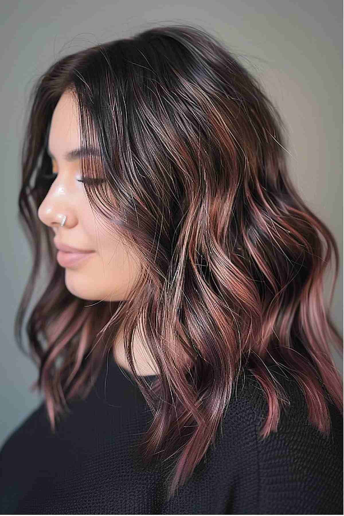 Medium-length dark hair with subtle waves and deep peach tones, offering a gentle warmth and easy maintenance while enhancing natural features.