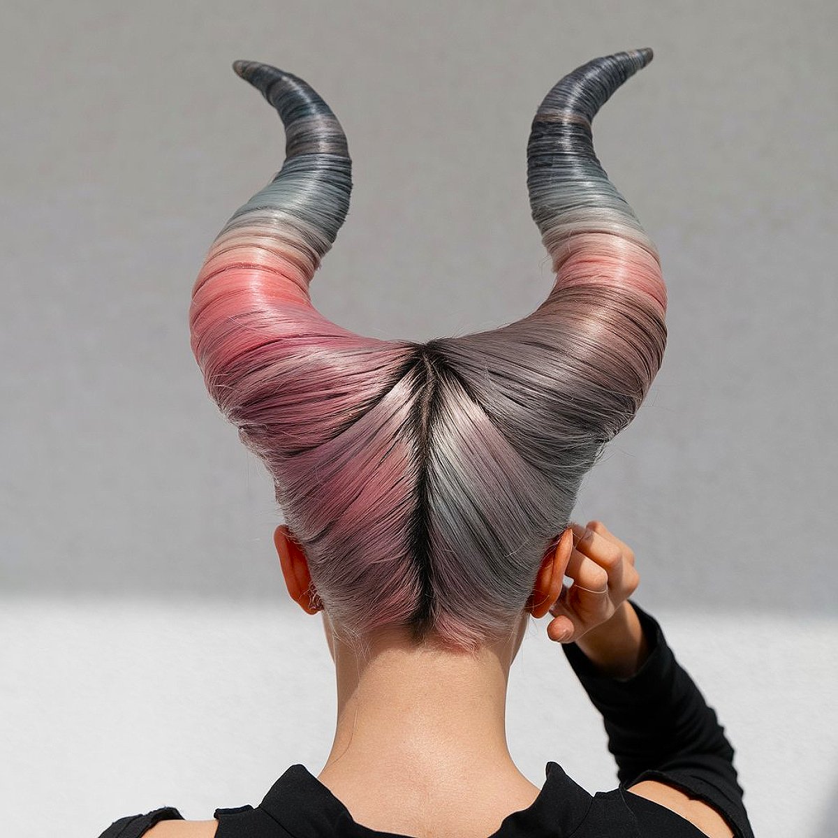 Fallen angel Halloween hairstyle with sculpted horns and pastel colors