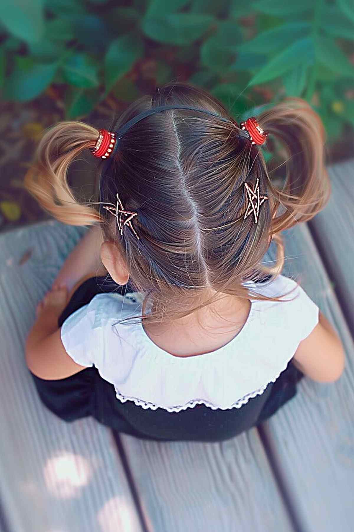 Little girl with double ponytails and star-shaped clips for 4th of July