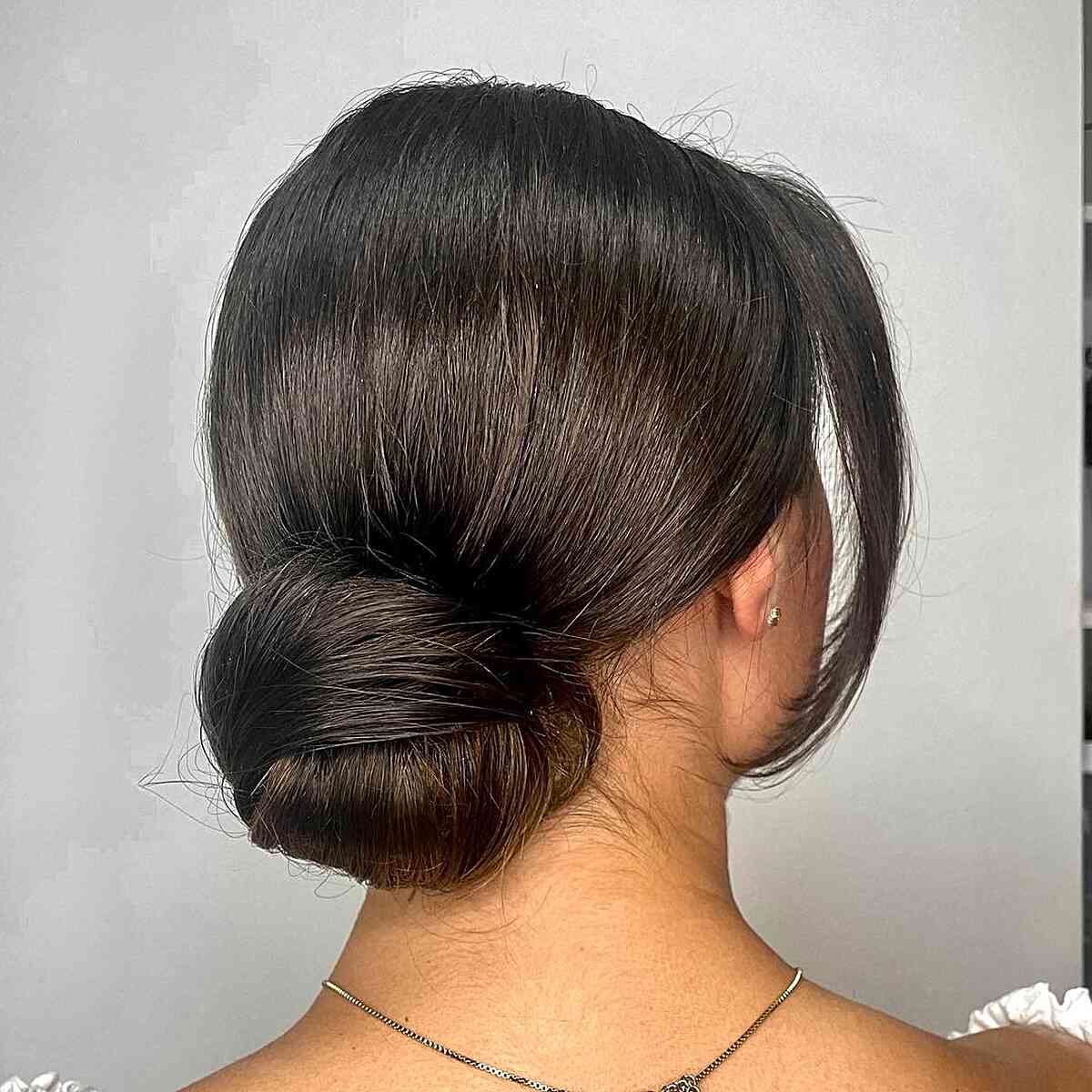 Easy Black Sleek Bun Hairstyle for Guests at Wedding Events