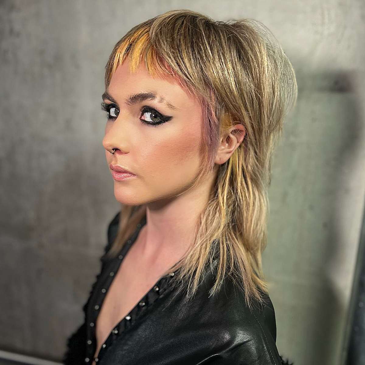 Edgy shaggy mullet with choppy layers and vibrant highlights on medium to thick hair