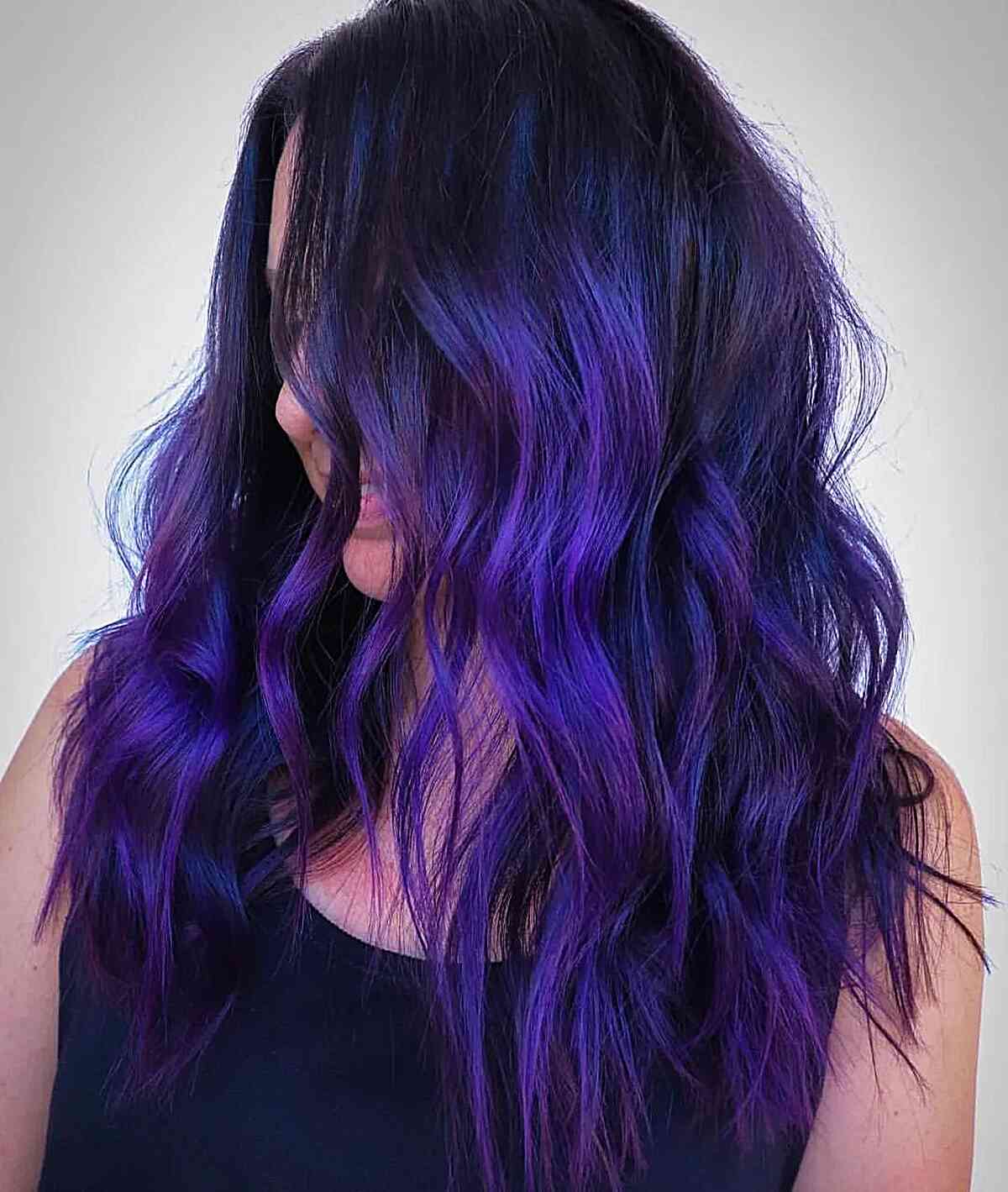 Electric Deep Purple with Blue Tint on medium-length hair with waves and dimension