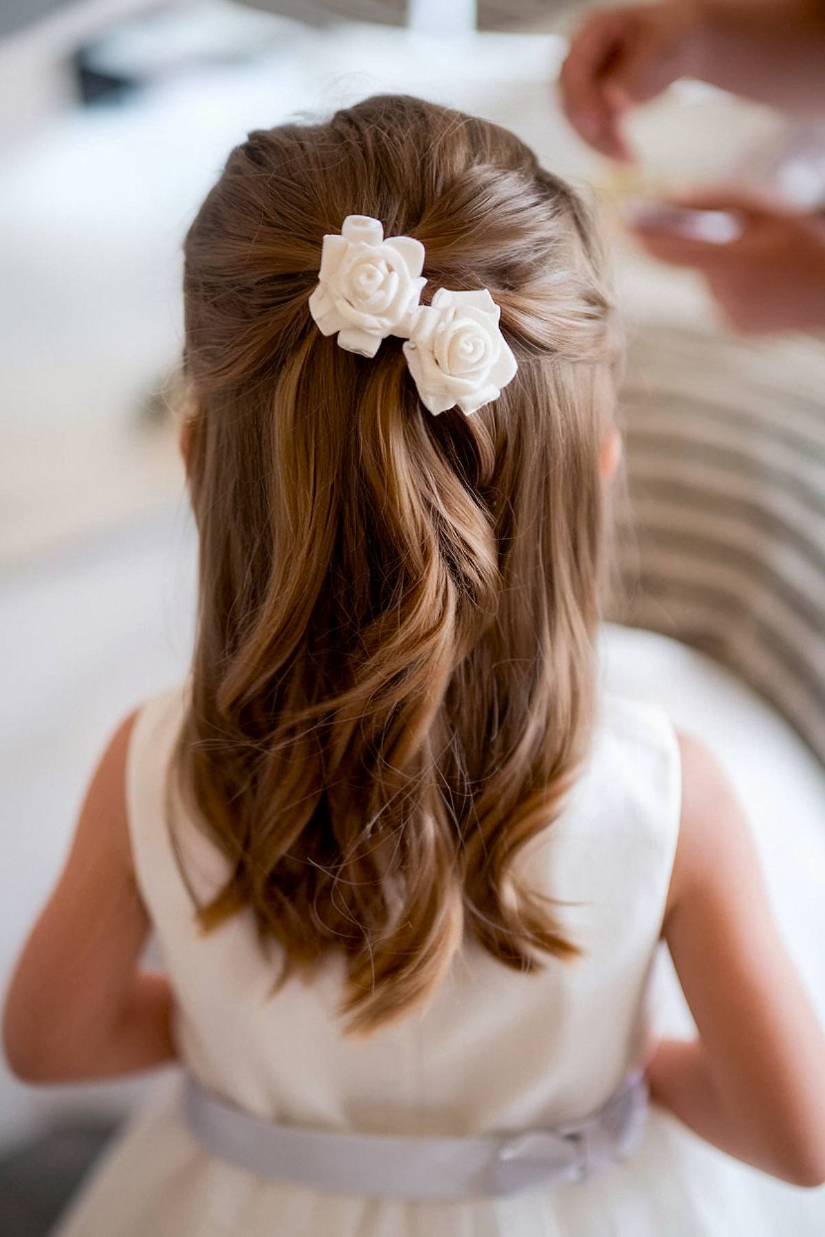 Braided crown toddler hairstyle with a pearl bow