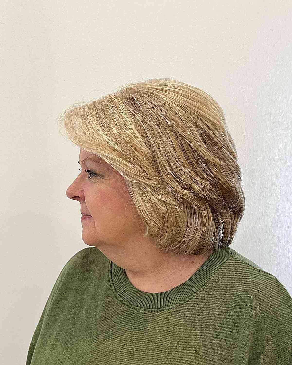 Face-Framing Bangs on Short Blonde Feathered Bob for Older Women