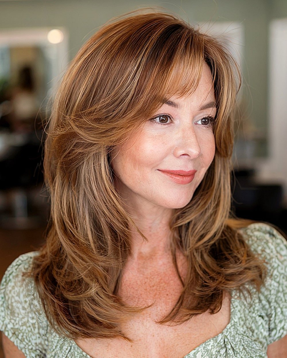Medium layered haircut with cinnamon highlights and side bangs perfect for fall hairstyle trends.