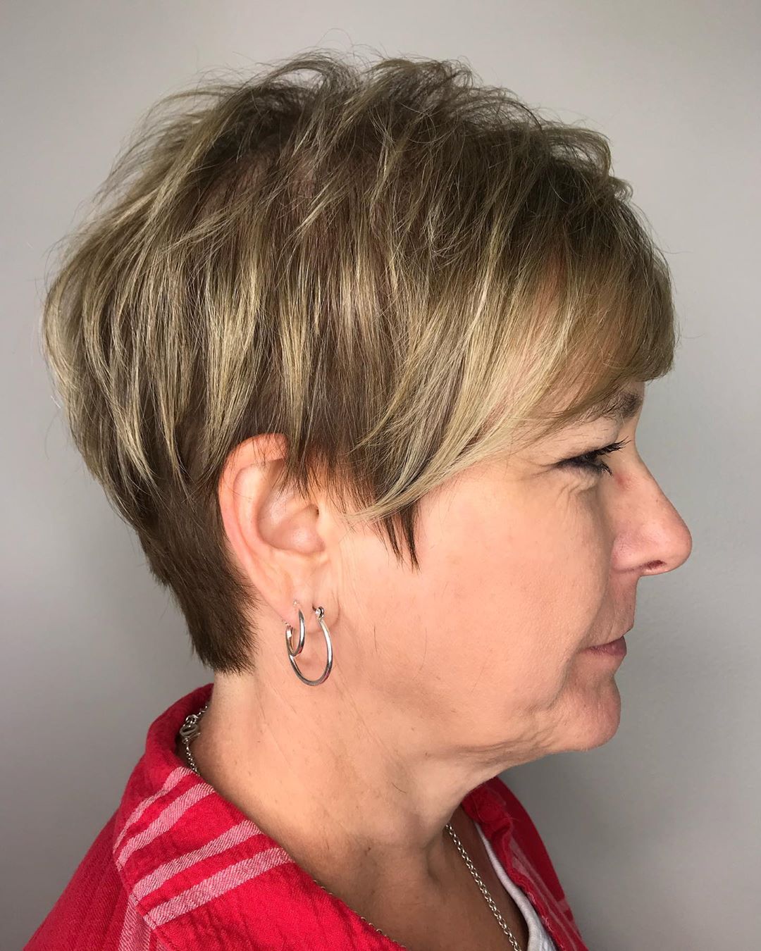 Polished feathered blonde pixie haircut for women over 70