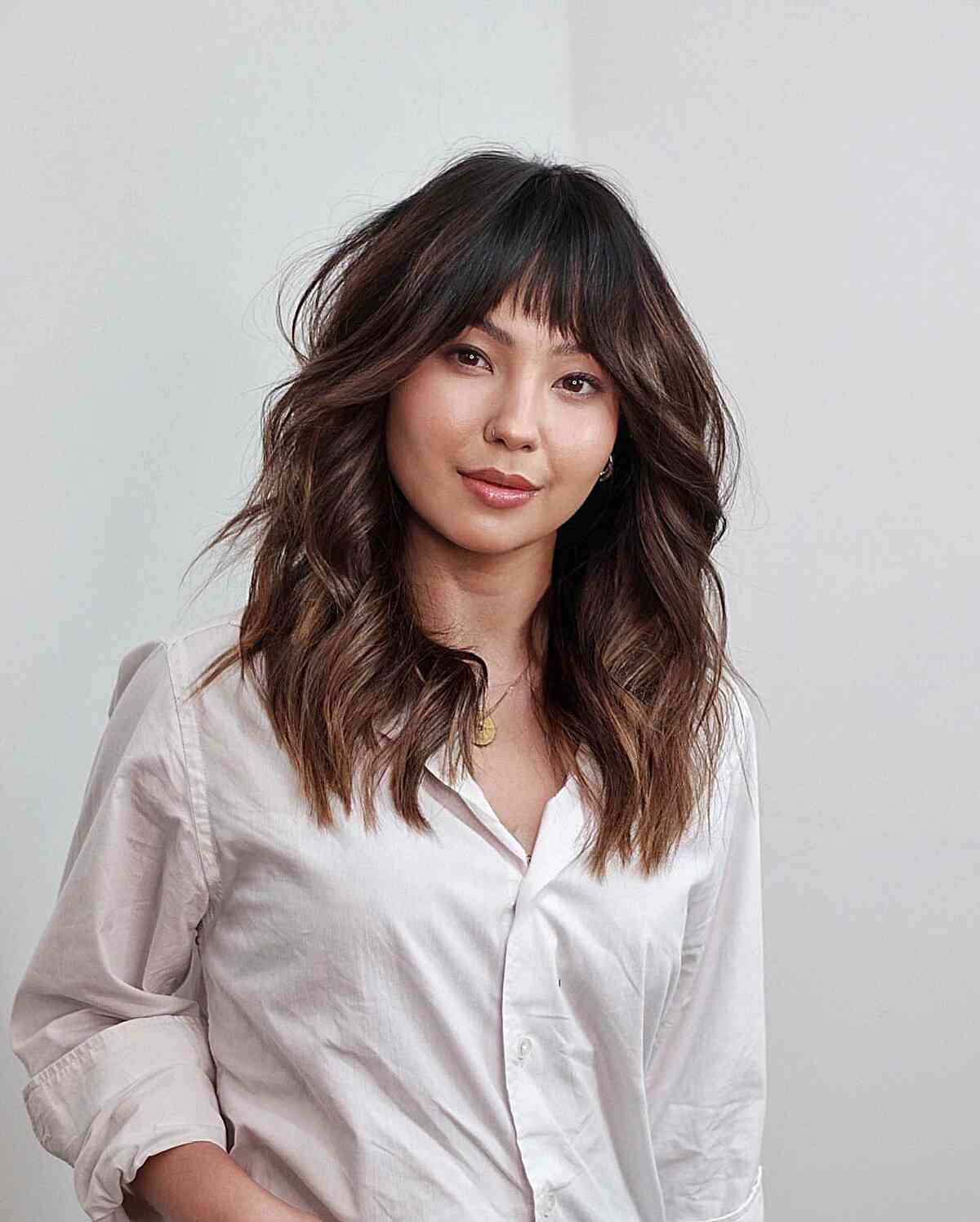 Feminine Mid-Length Loose Waves with Bangs for a Heart Face
