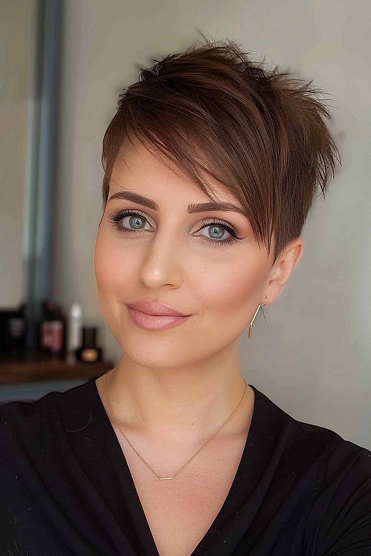 Feminine razor cut pixie with long side-swept bangs for oval and heart-shaped faces