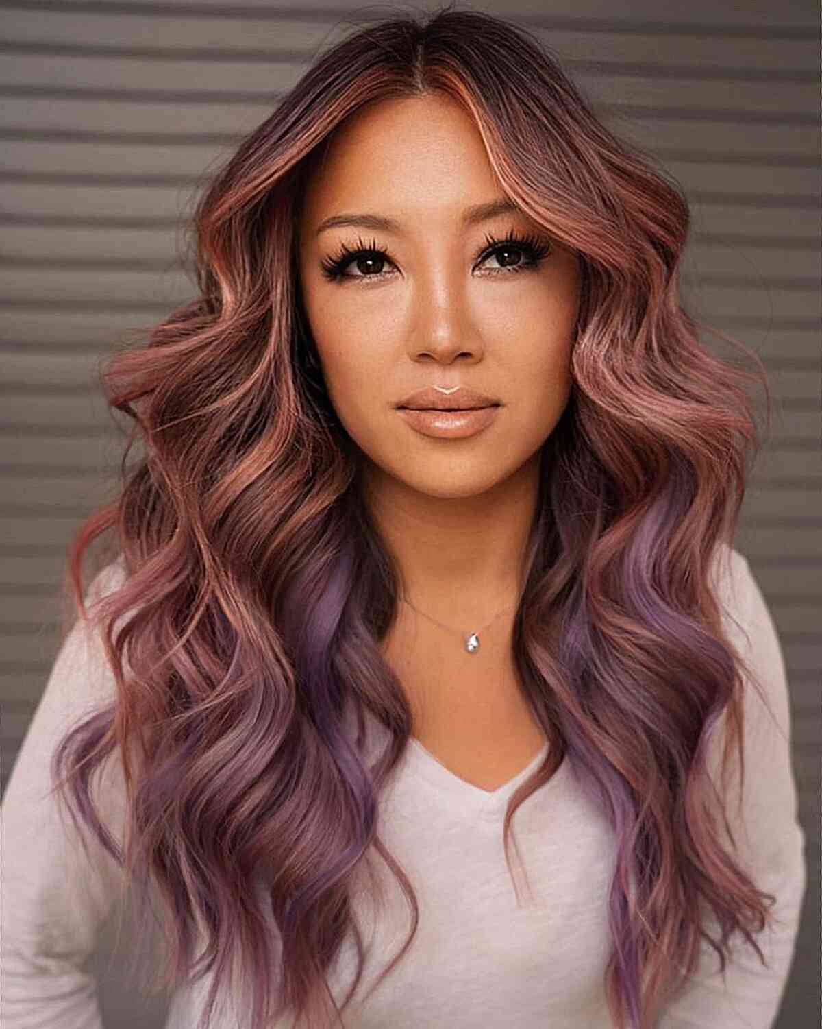 Flowing Rose Gold with Purple Peekaboo Highlights on women with long thick hair