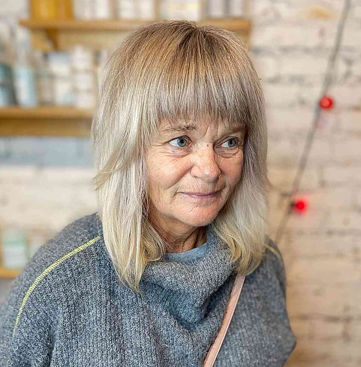 Foil Highlights on Mid-Length Blonde Hair with Bangs for women in their 60s