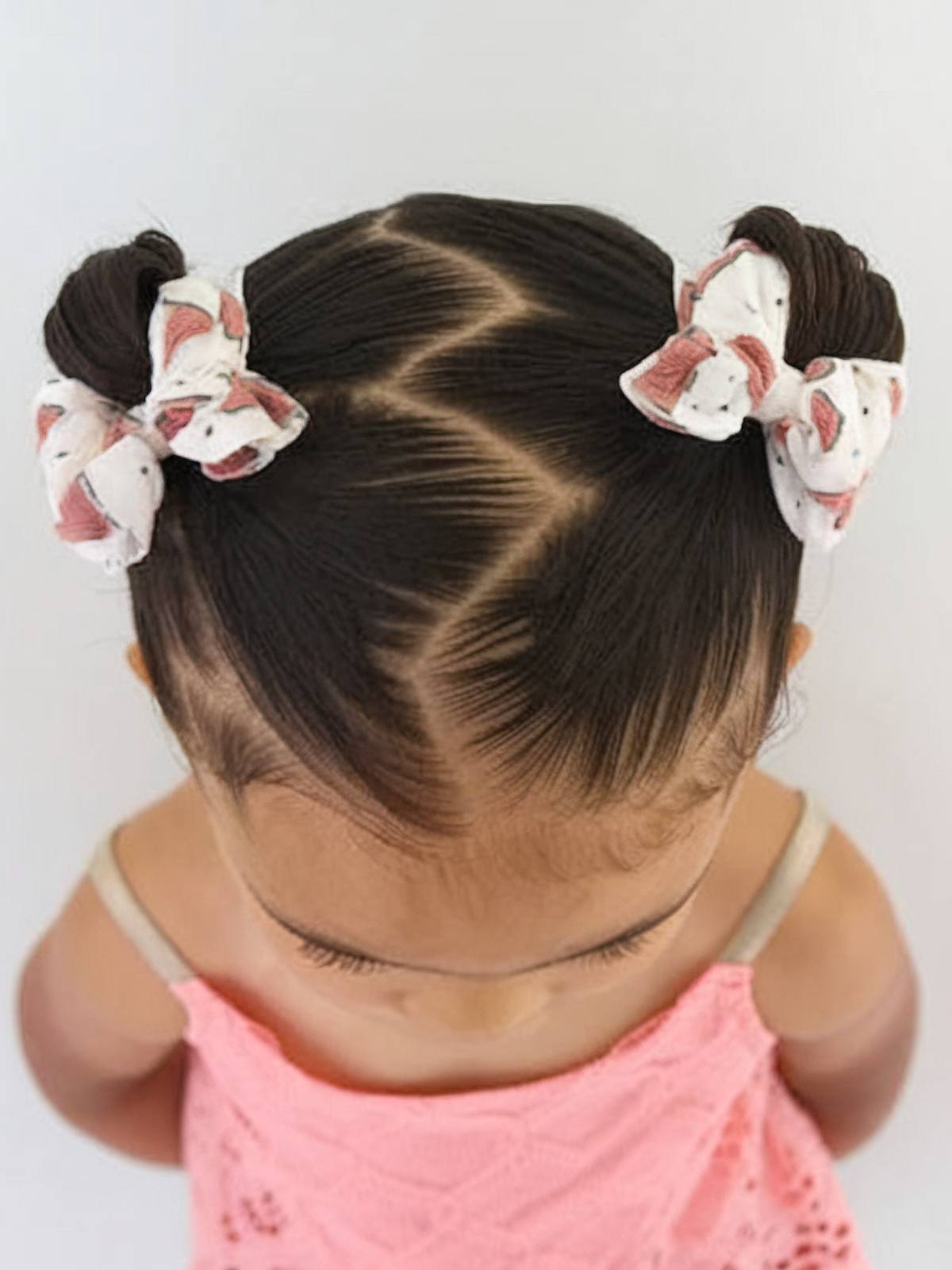 Toddler hairstyle with zig-zag part and double buns