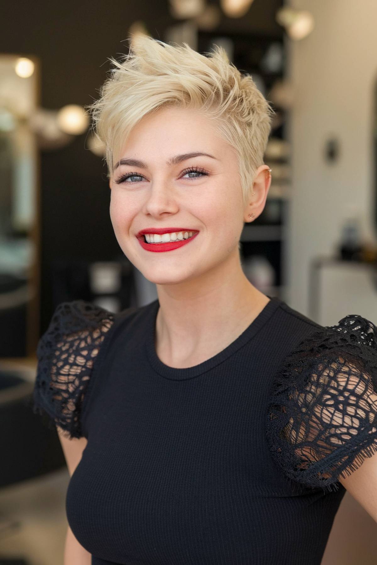 Blonde pixie cut with a spiky mohawk style and shaved sides for a bold, edgy look