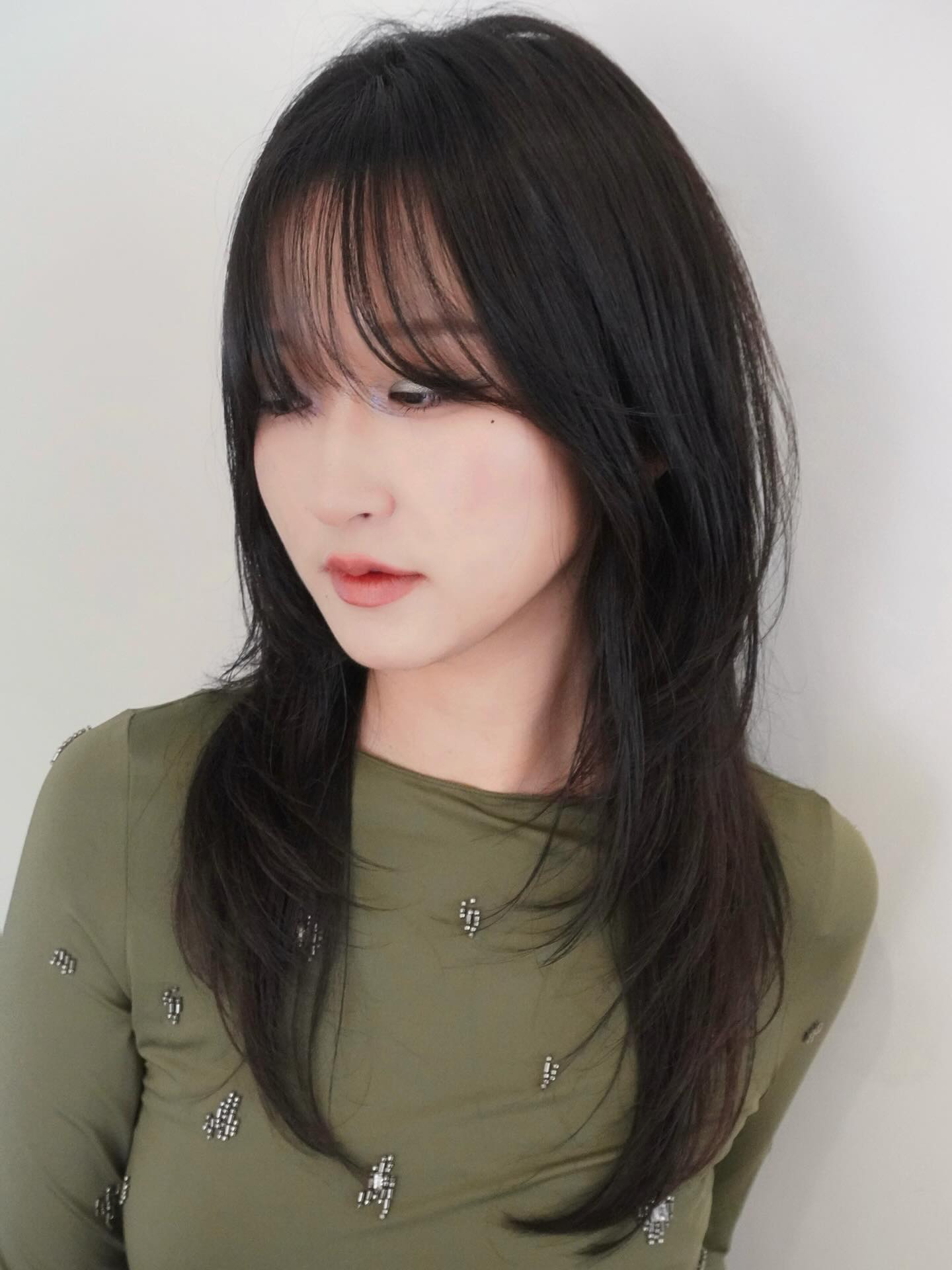 Sleek Jet-Black Cascading Cut with Side-Swept Bangs