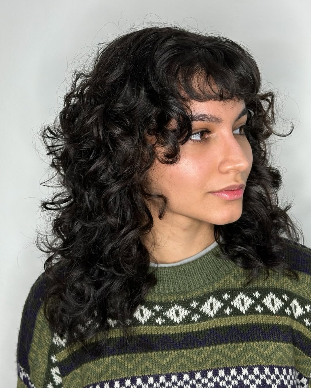 Deep-Black Voluminous Curls with Classic Bangs