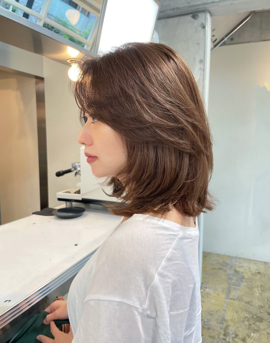 Sleek Ash-Brown Layered Bob with Side-Swept Fringe
