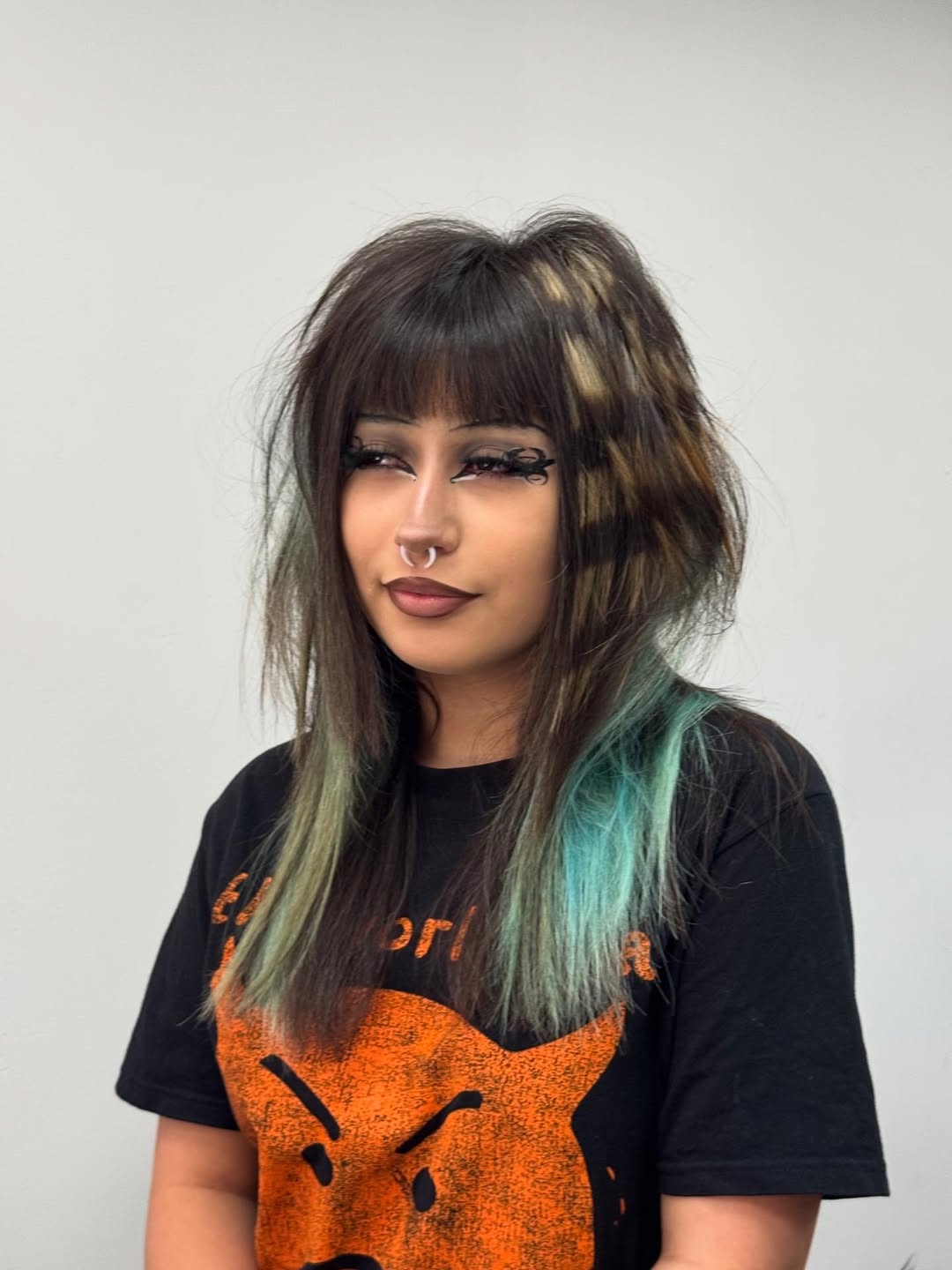 Edgy Brunette Shag with Teal Highlights and Wispy Bangs