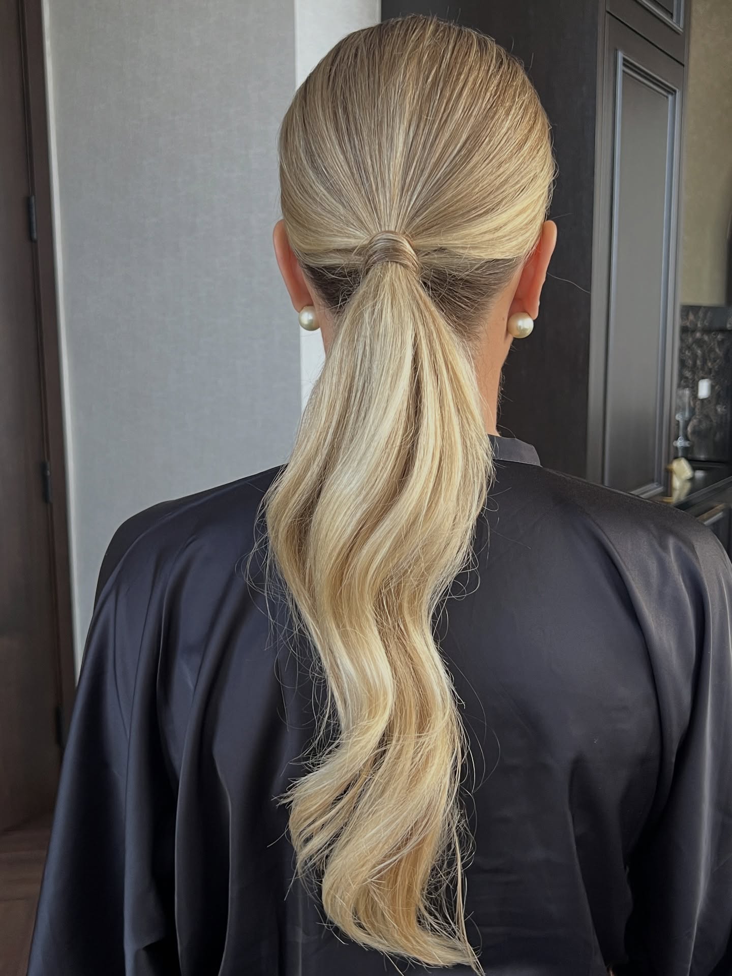 Sleek Wrapped Low Ponytail with Soft Waves and Root Shadow