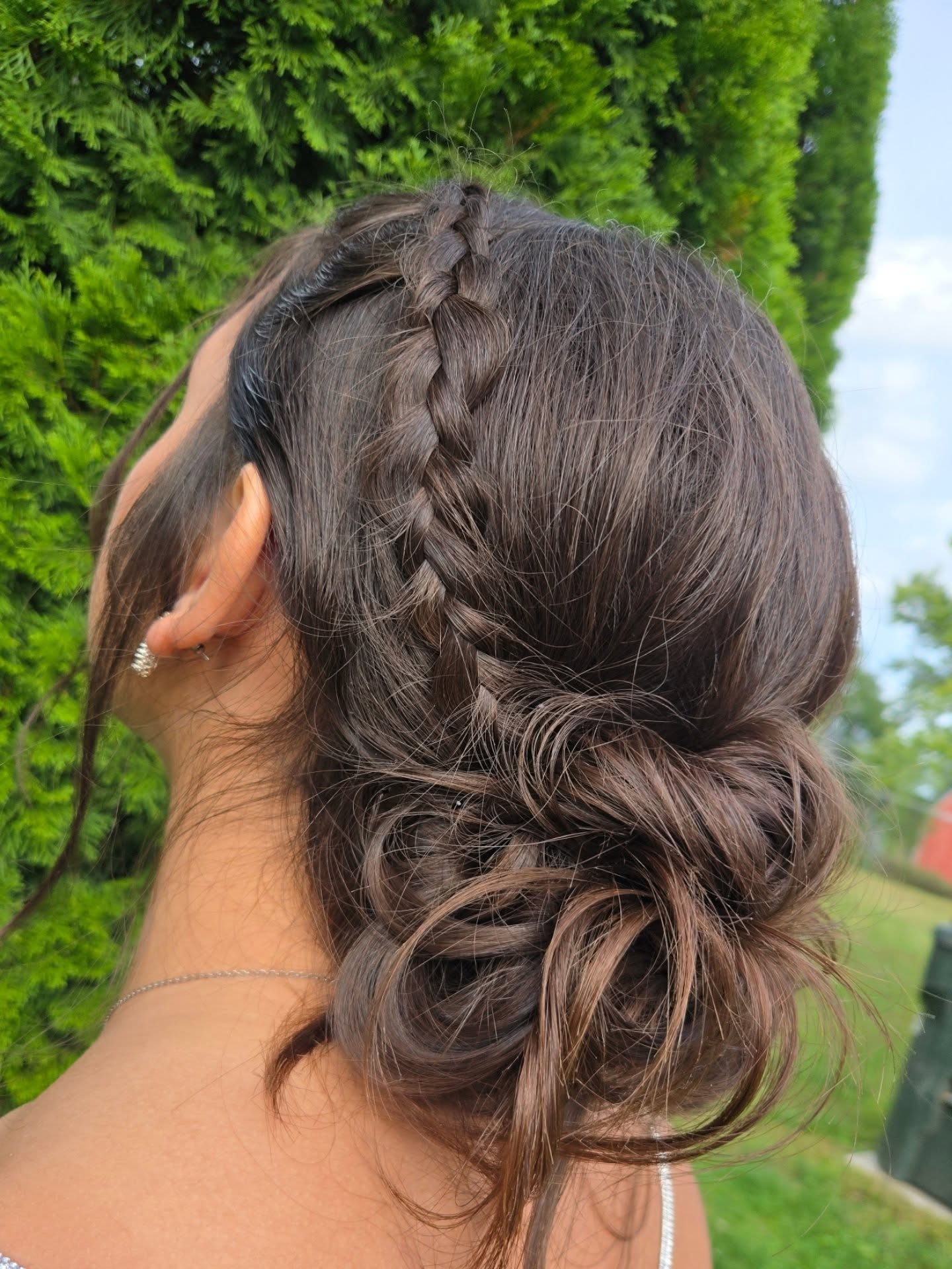 Loose Side Braid Anchored Low Bun with Face‑Framing Tendrils