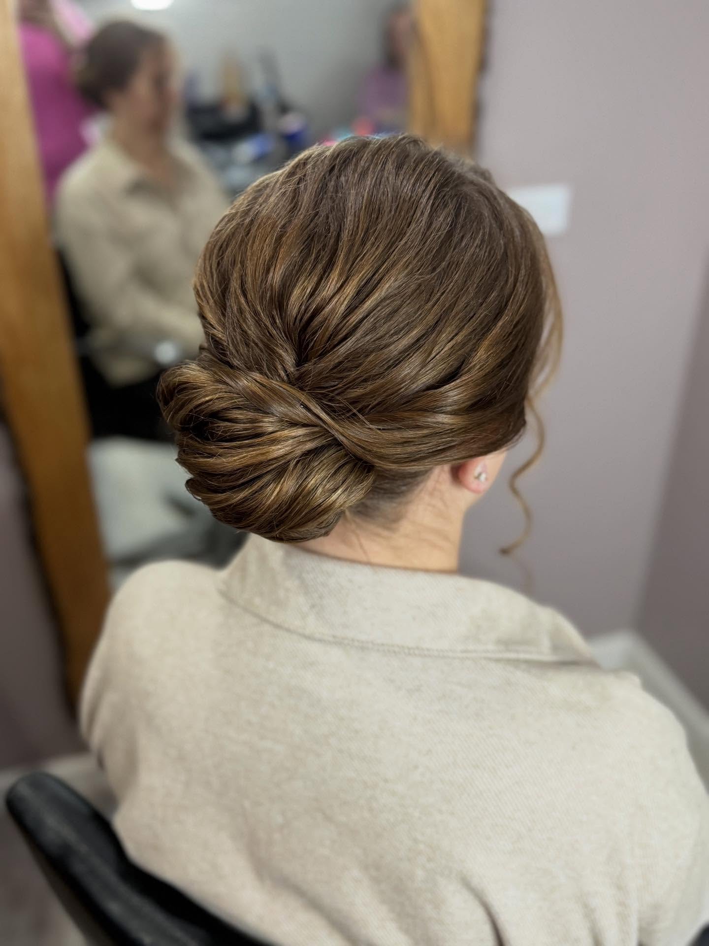 Polished Low Tuck Twist Bun with Soft Face‑Framing Tendril