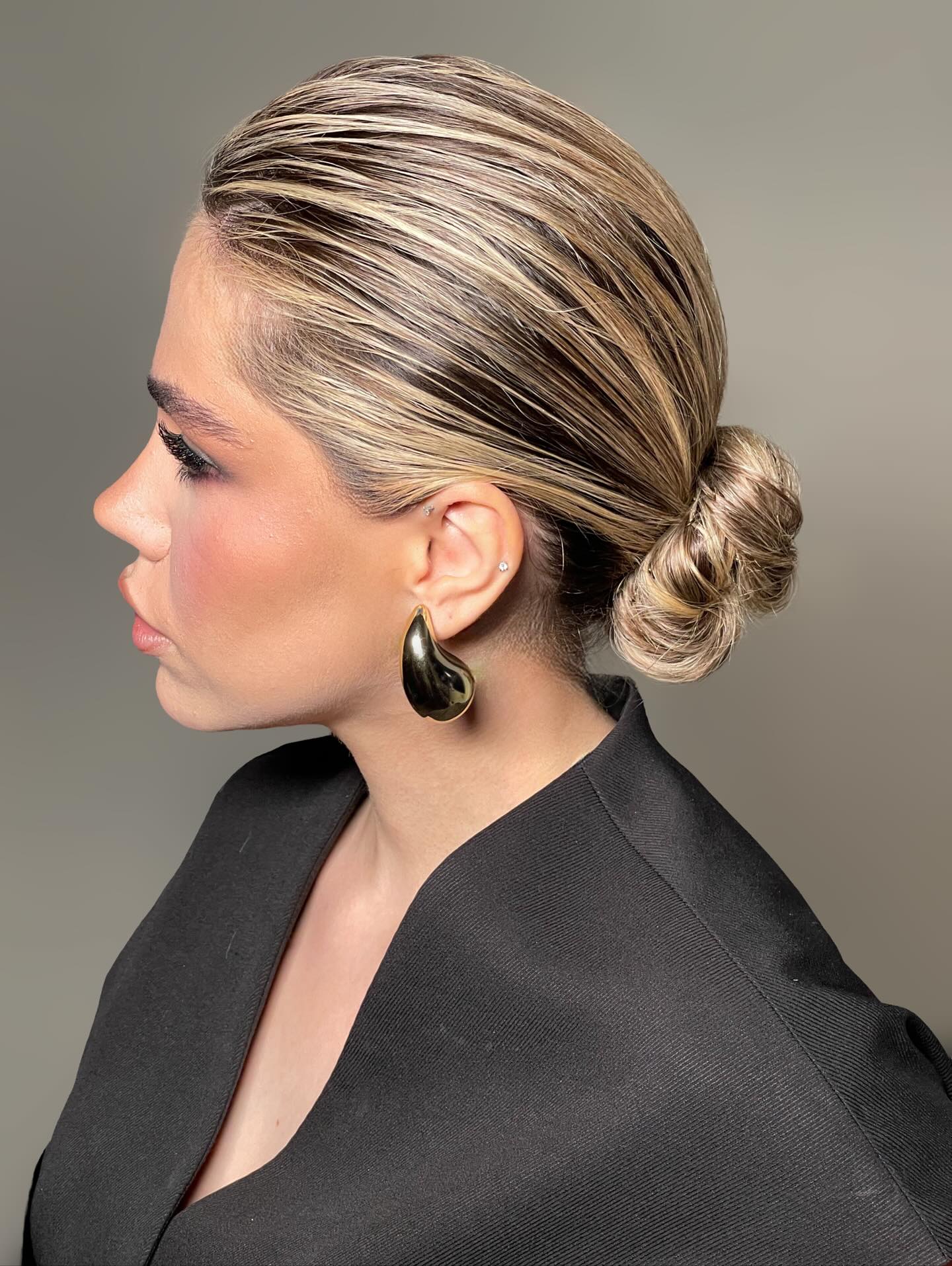 Sleek Root-Shadow Low Twisted Bun with Painted Blonde Highlights