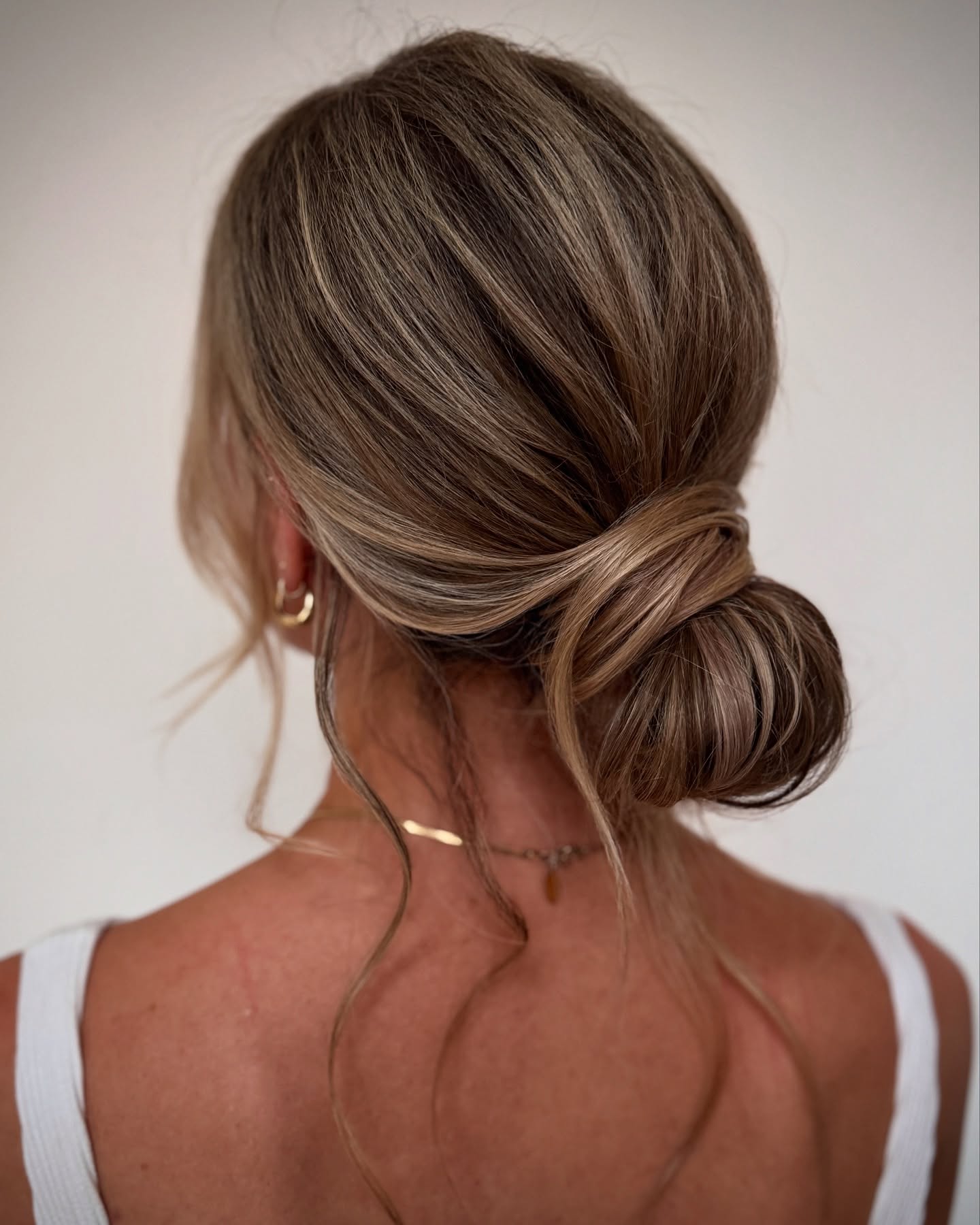 Elegant Textured Low Bun with Soft Face-Framing Waves