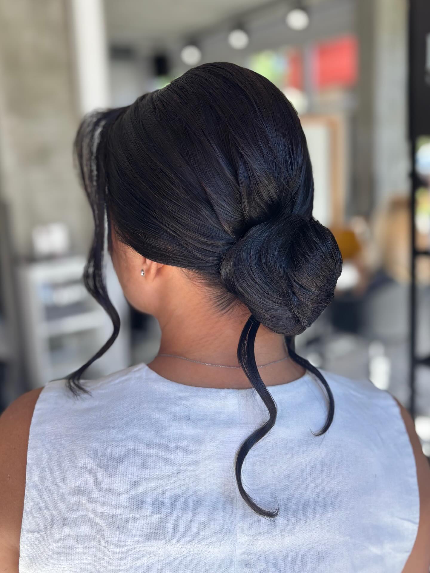 Modern Low Chignon with Playful Face-Framing Curls