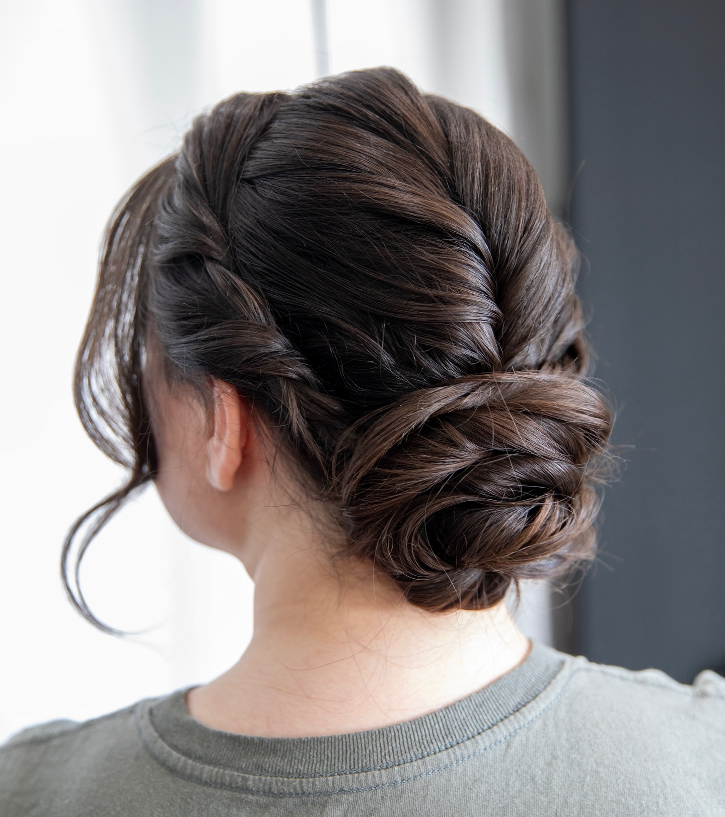 Elegant Braided Low Bun with Soft Tendrils