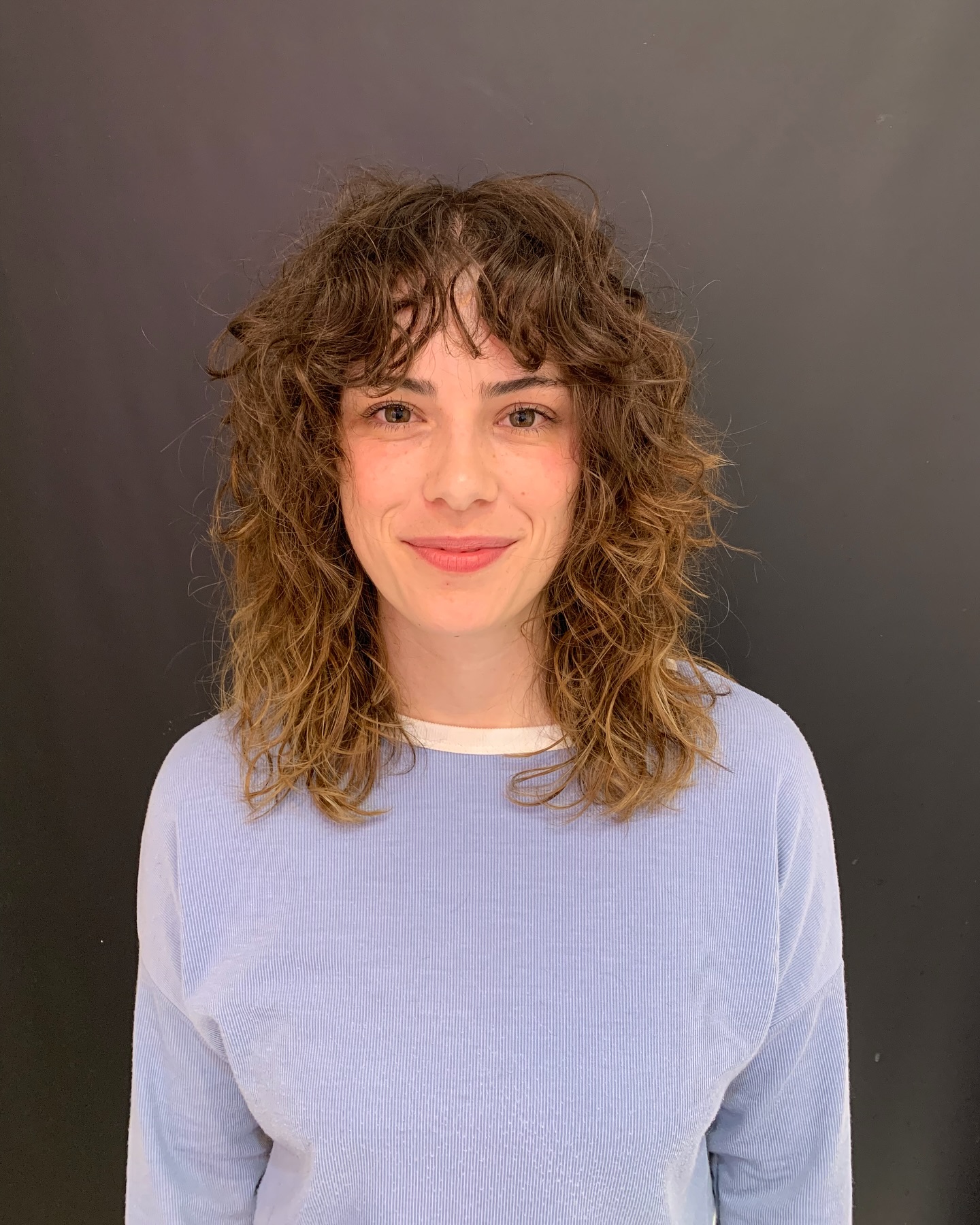 Playful Curly Mid-Length Cut with Soft Bangs
