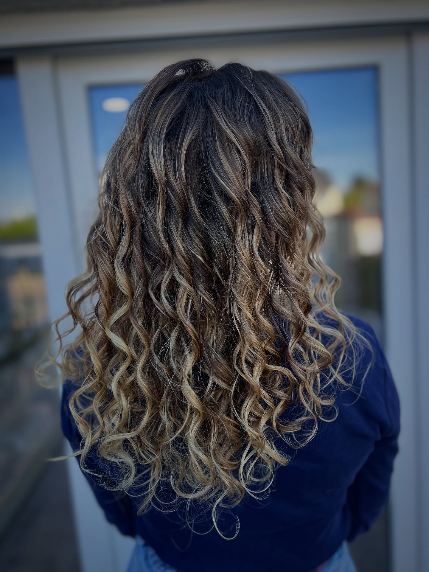 Beautifully Defined Curly Length with Subtle Balayage
