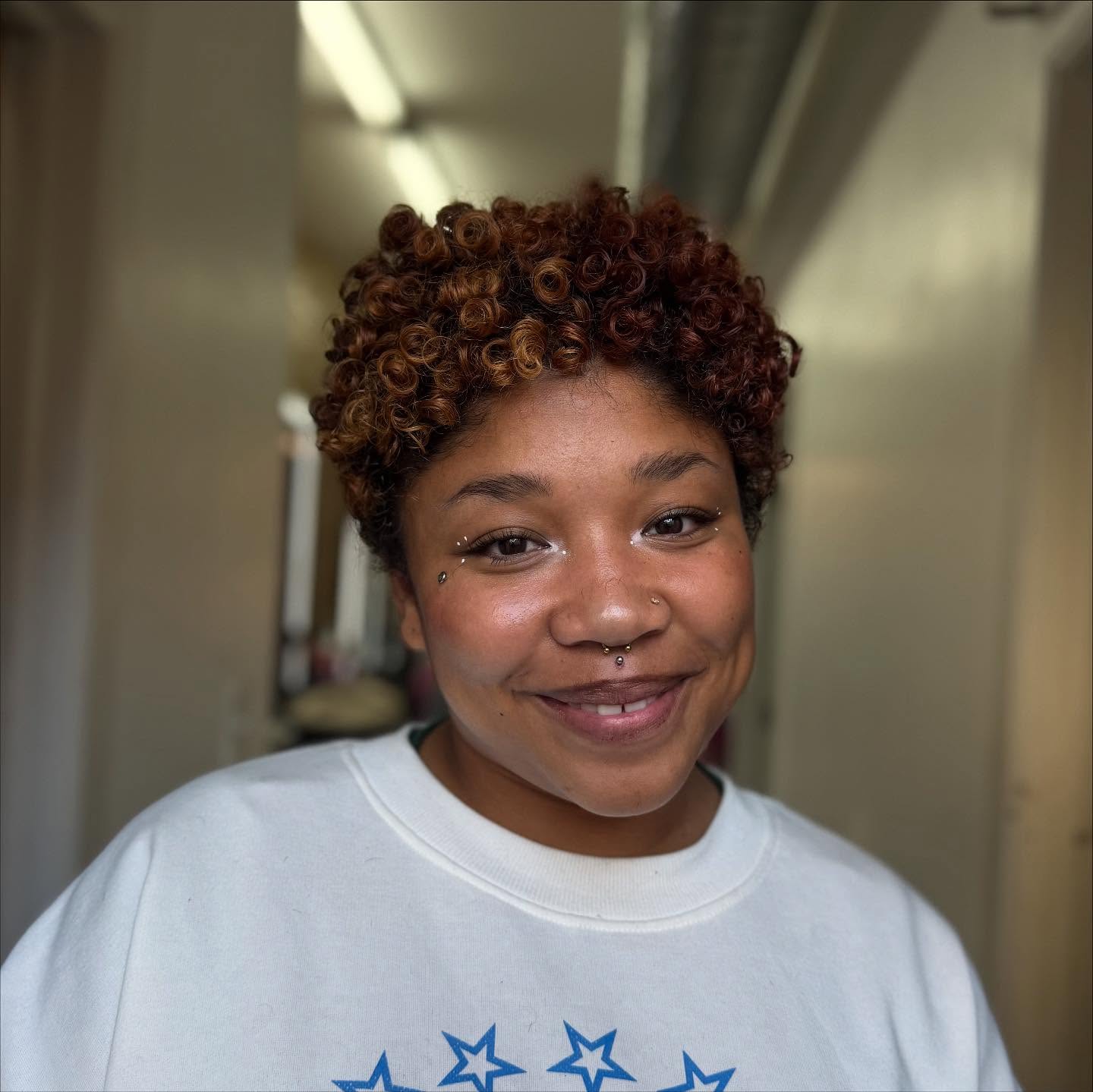 Charming Short Curly Hairstyle with Warm Highlights