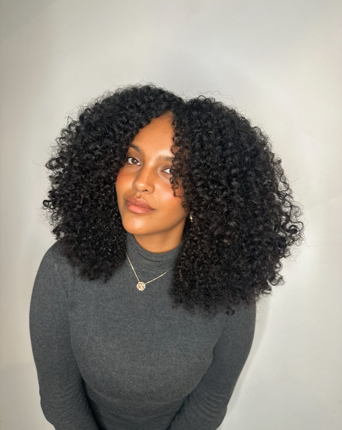 Voluminous Curly Mid-Length Cut with Face-Framing Layers
