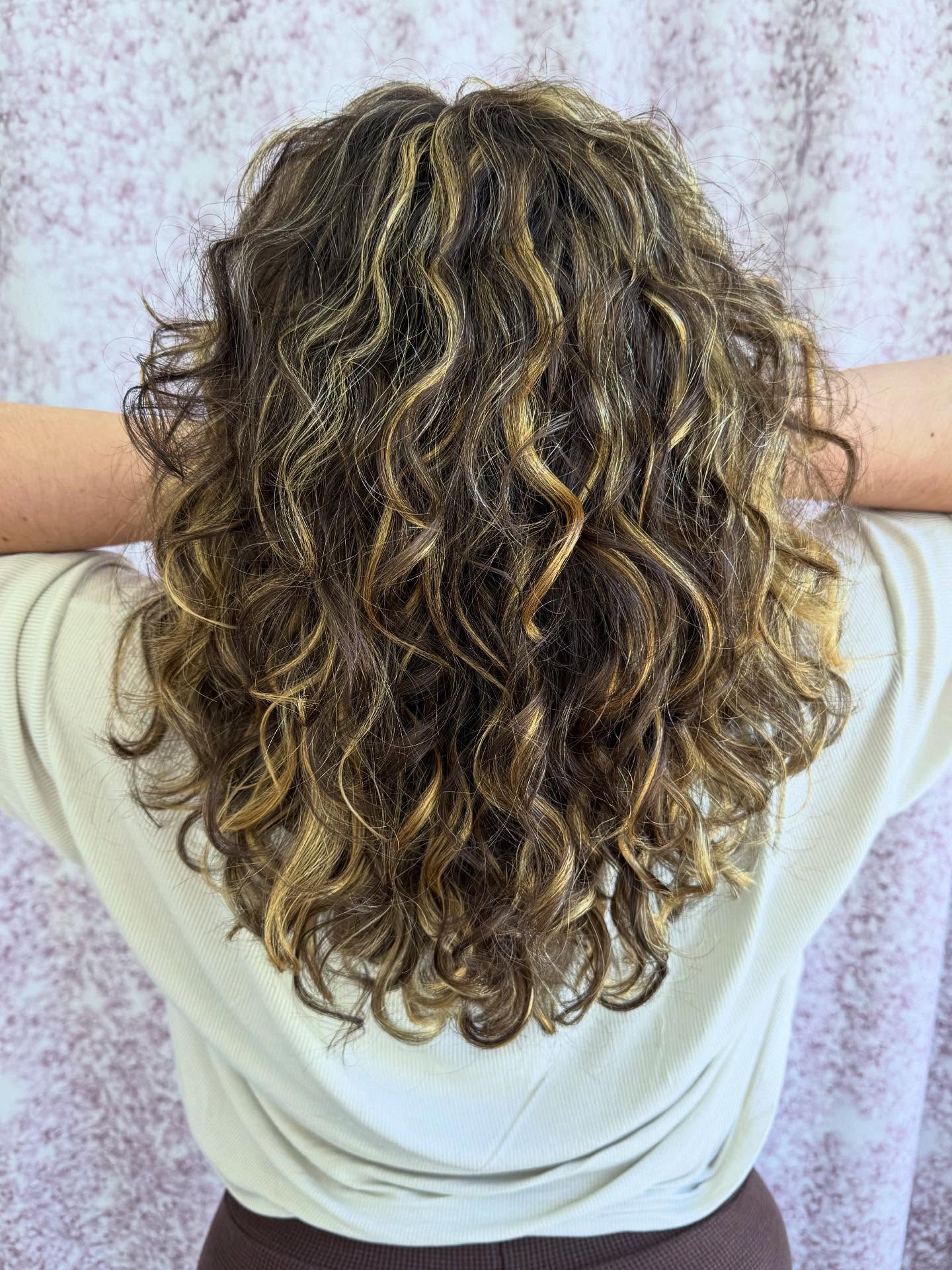 Textured Curly Shoulder-Length Cut with Golden Highlights