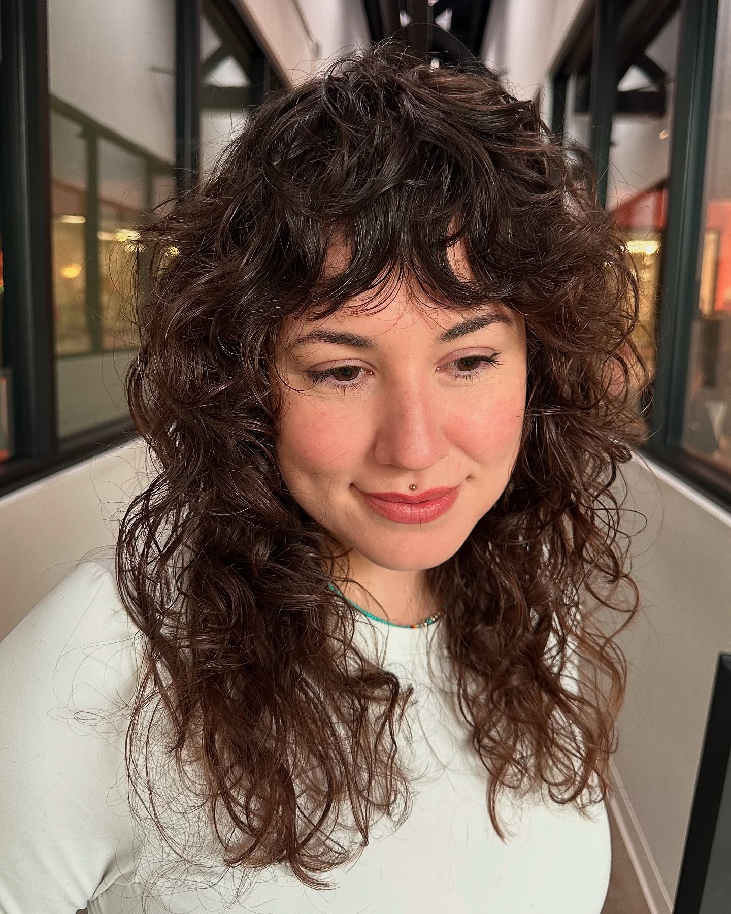 textured curly mid length shag with wispy bangs