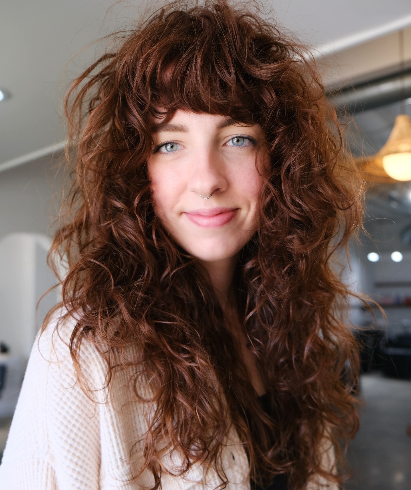 Chic Curly Hair with Bold Heavy Bangs