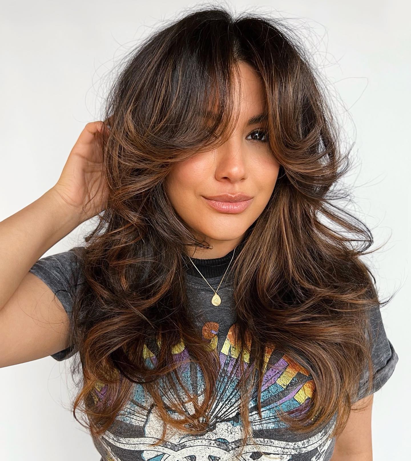 Bold Voluminous Feathered Bangs with Warm Highlights