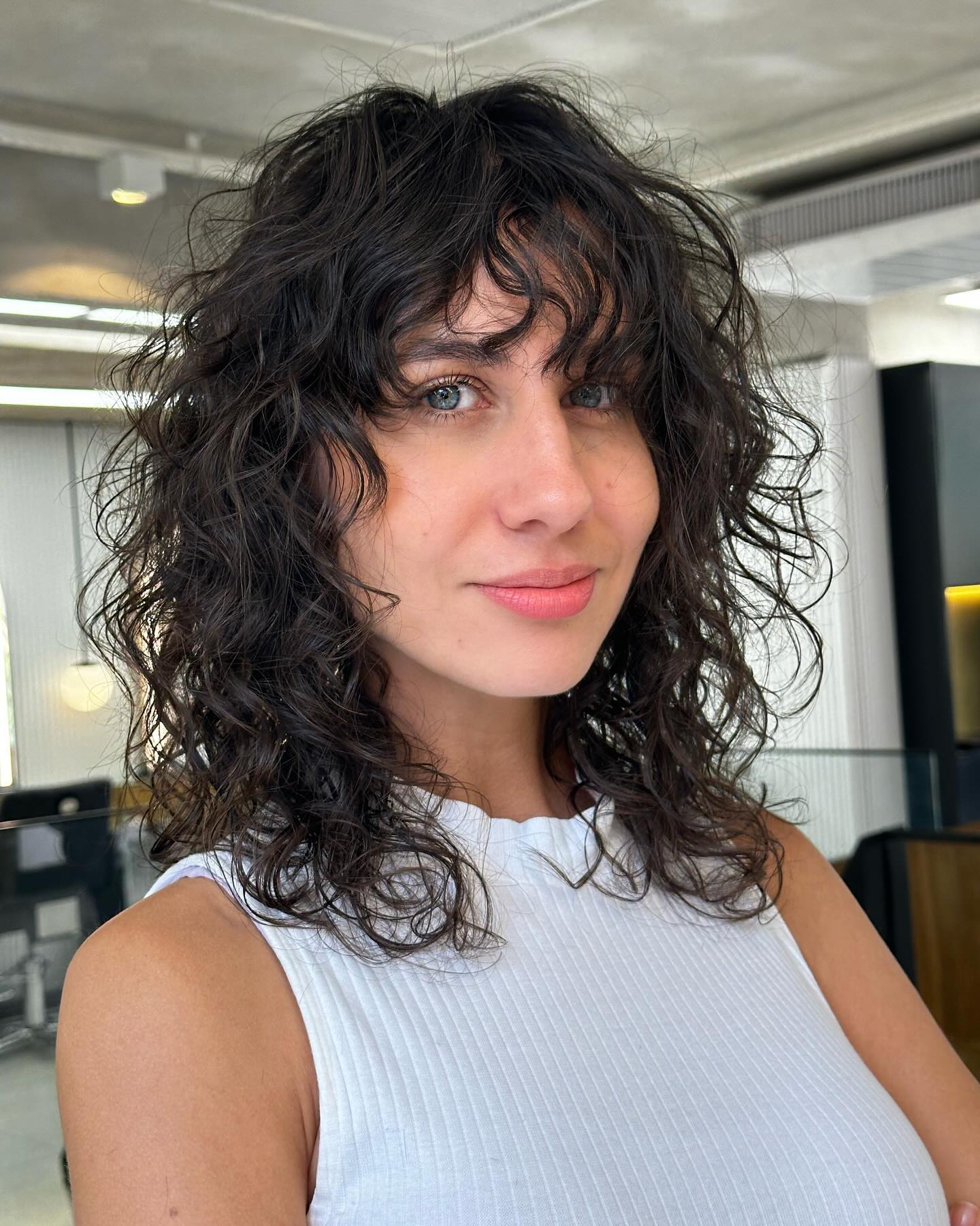 Chic Curly Shoulder-Length Cut with Soft Bangs