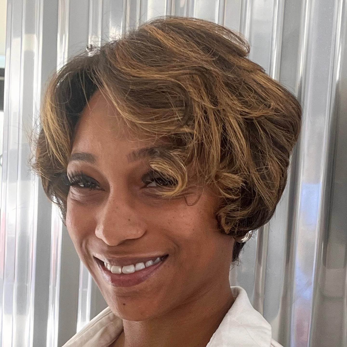 Chic Curly Bixie Cut with Subtle Highlights