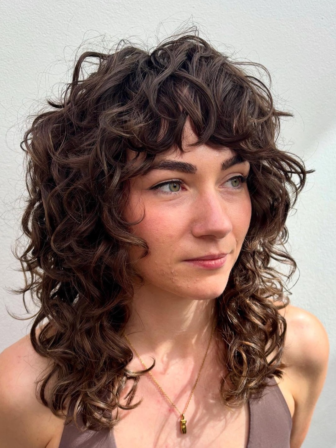 Textured Curly Shoulder-Length Cut with Soft Bangs