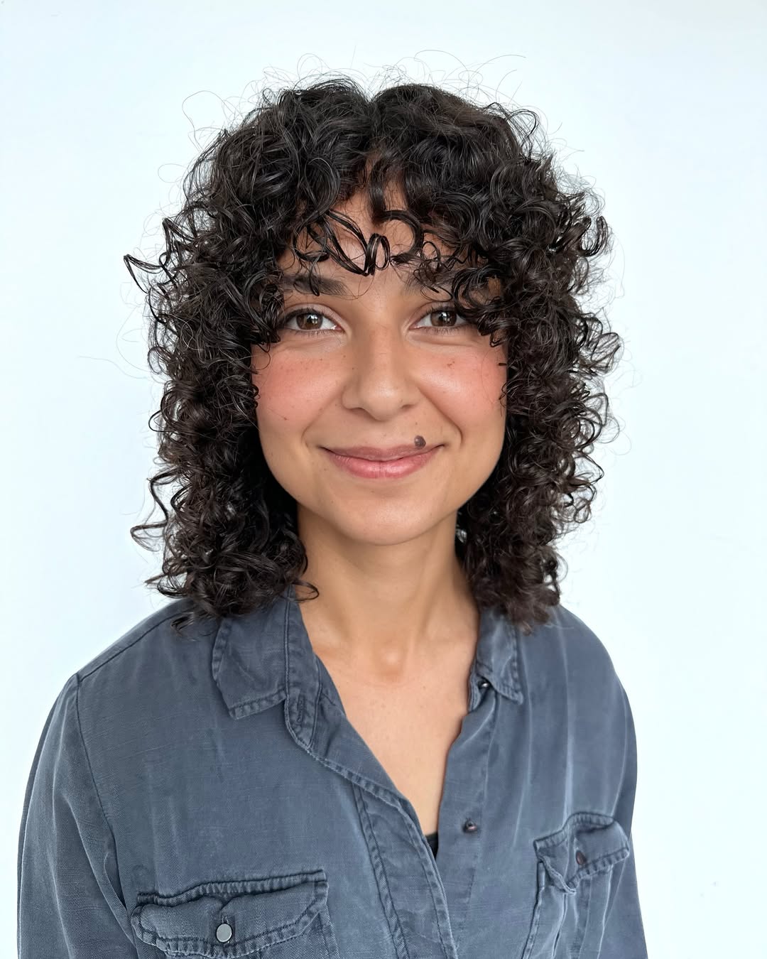 Curly Layered Cut with Playful Bangs